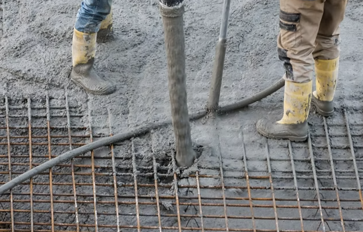 Reinforced concrete being poured onto a prepared base