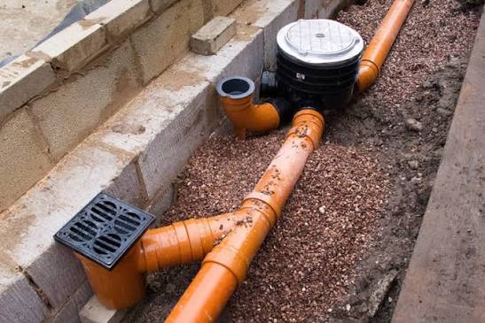 Land drainage pipes and soakaway installation in a trench